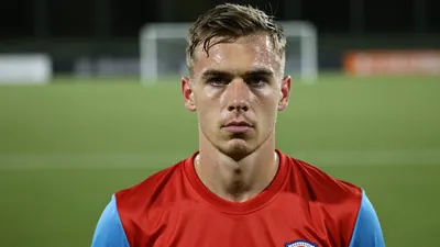 Mid-30s GIF Sundsvall midfielder, athletic build, intense gaze, head-and-shoulders, wearing a plain red shirt with...