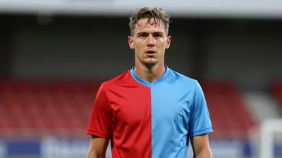 Mid-30s GIF Sundsvall midfielder, athletic build, waist-up, intense expression, sweat glistening on forehead, wearing a...