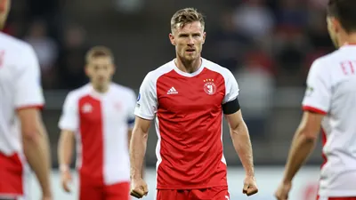 A 30-year-old GIF Sundsvall defender in a red and white jersey, standing in the penalty area with a determined...