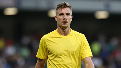 A mid-30s anonymous GIF Sundsvall player in a solid yellow jersey, waist-up, focused expression, background blurred...