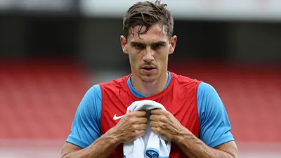 Mid-30s GIF Sundsvall midfielder, athletic build, waist-up, intense gaze, drenched in sweat, wearing a plain red shirt...